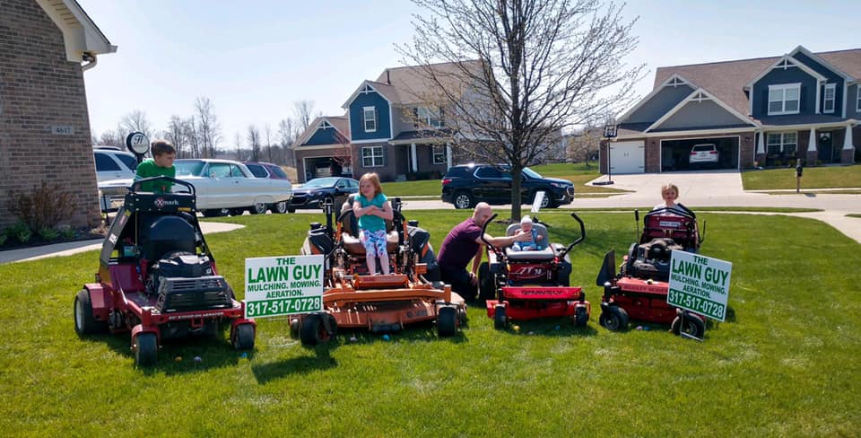 The Lawn Guy's ExMark mower fleet with the kids — ready for the season