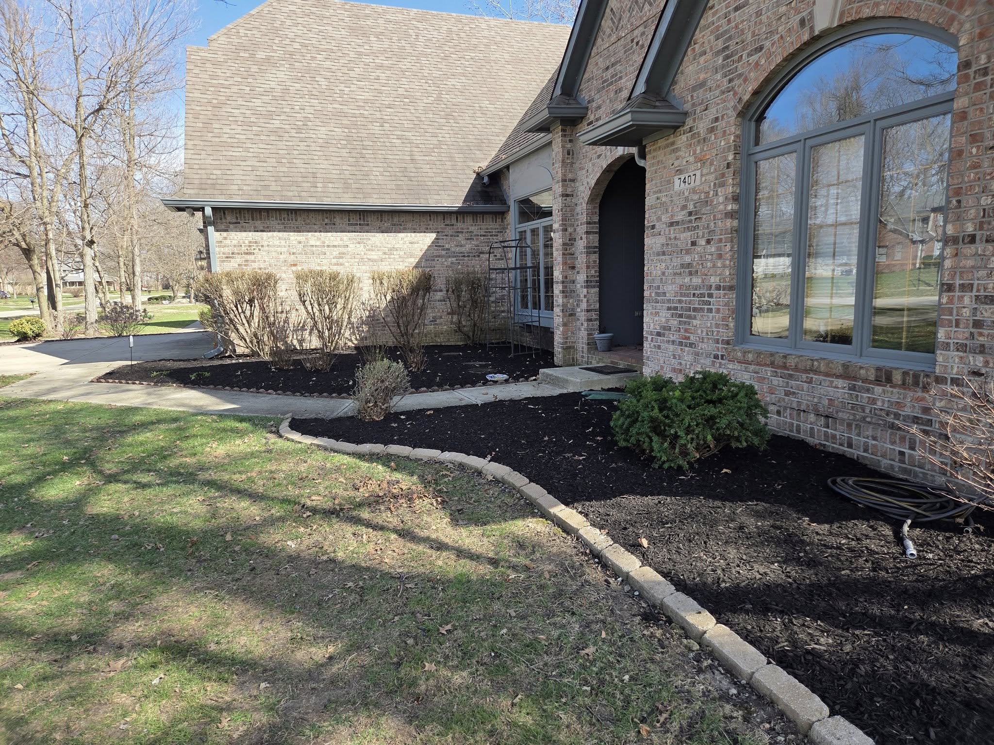 Fresh mulch install along a brick home — The Lawn Guy